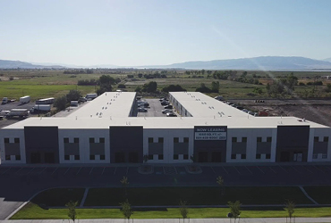 A large warehouse space with a now leasing sign hanging on the front.